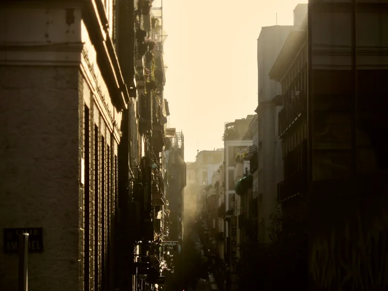 Rayos de sol cayendo sobre una estrecha calle mediterránea